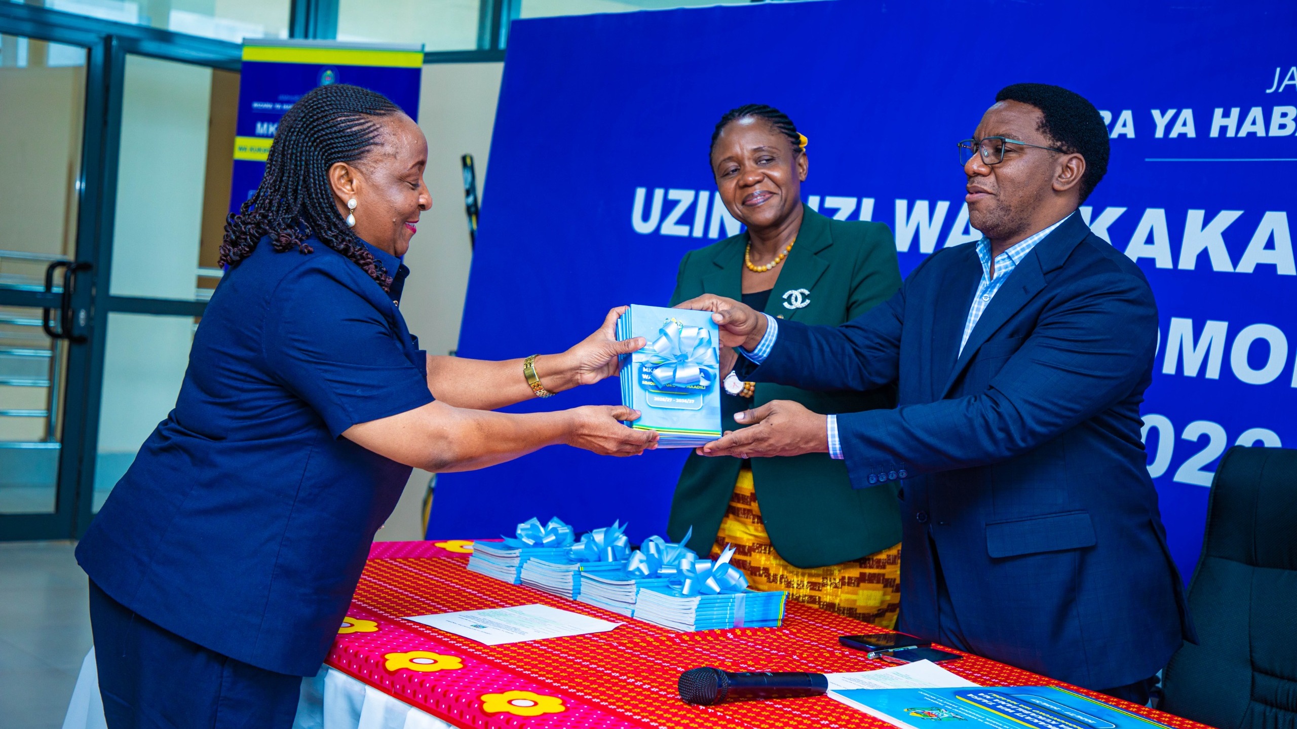 Katibu Mtendaji wa Baraza la Kiswahili la Taifa (BAKITA) Bi. Consolata Mushi  akikabidhiwa Mkakati wa Taifa  wa Kukabiliana na Mmomonyoko wa Maadili na Waziri wa Habari, Utamaduni, Sanaa na Michezo Mhe. Paul Christian Makonda.